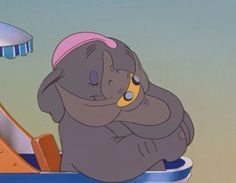 an elephant sitting on top of a blue and white boat with a pink hat on