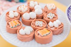 there are many sushi rolls on the plate with marshmallows in them