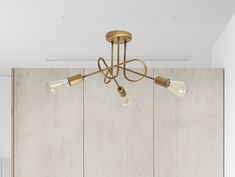 three light brass chandelier with glass shades on wood paneled wall in kitchen