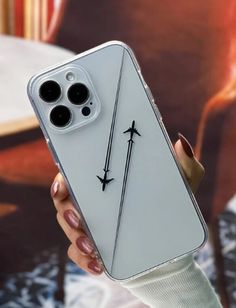 a person holding up a white iphone case with two swords drawn on the back of it