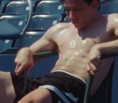 a shirtless tennis player sitting in the stands