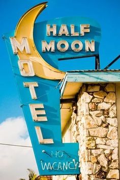 a motel sign with the moon on it's side in front of a building