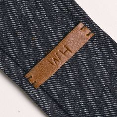 there is a brown leather tag on the back of a blue suit pants that says, i have