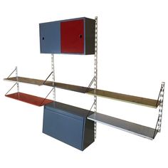 three metal shelvings with red and blue shelves on each side, one is empty