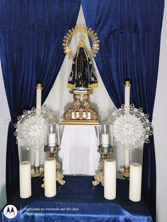 the altar is decorated with white candles and blue drapes, which are adorned with gold trimmings