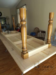 an unfinished bed frame with two wooden posts