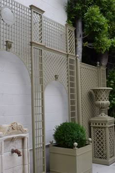 an outdoor area with potted plants and trelliss on the side of the building