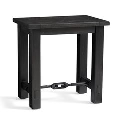 a small black table with a metal frame on it's legs and an iron bar at the top