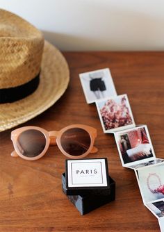 a hat, sunglasses and some pictures on a table