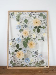 a wooden frame with flowers and leaves on it