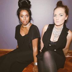 two women sitting on the floor in black outfits