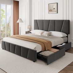 a bed with two drawers underneath it in a white and beige bedroom area next to a large window