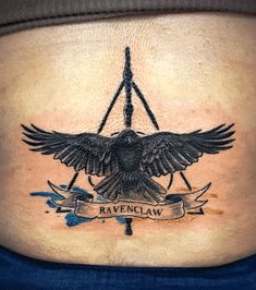 the back of a woman's stomach with an eagle and banner tattoo on it