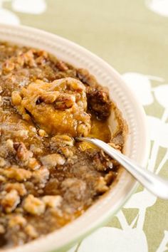 a close up of a bowl of food on a table with a spoon in it