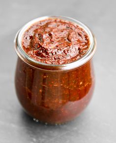 a jar filled with red sauce sitting on top of a table