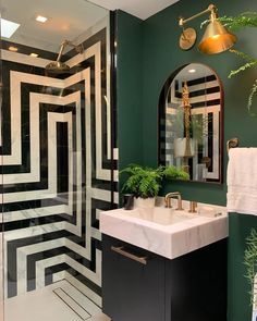 a bathroom with green walls and black and white tiles on the floor, along with a marble sink