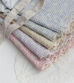 a stack of cloths sitting on top of a white lace doily next to each other