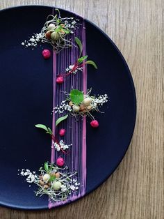 a blue plate topped with different types of food on top of a wooden table next to a knife and fork