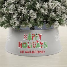 a potted christmas tree with the words happy holidays in red, white and green