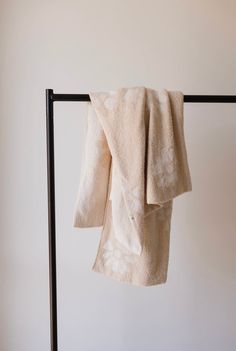 two white towels hanging on a black rack