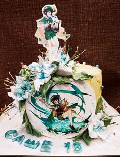 a decorated cake with anime characters on it's sides and flowers around the edges