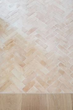 a wooden floor with a white and brown tile pattern on the top part of it