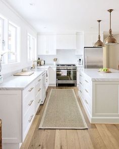 an instagramted photo of a kitchen with white cabinets