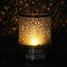 a candle that is lit up with stars in the sky on it's side