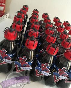 a bunch of soda bottles sitting on top of a white table with red and blue caps