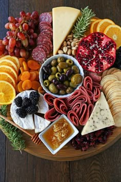 a wooden platter filled with different types of cheeses and fruit on top of it