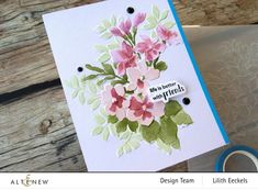 a close up of a greeting card with flowers on it and a ribbon around the edge