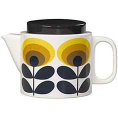 a tea pot with yellow and black flowers painted on the front, sitting next to a white background