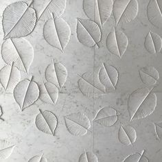 white leaves are arranged on the wall in this artistic pattern, which looks like it has been