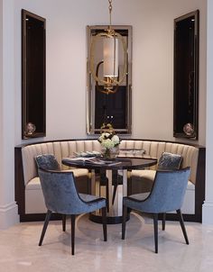 a round table with four chairs around it in a dining room that has white walls and marble flooring