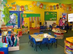 a classroom filled with lots of desks and colorful decorations on the wall above them