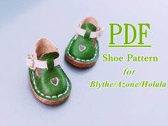 a pair of green baby shoes with hearts on the front and bottom, are shown