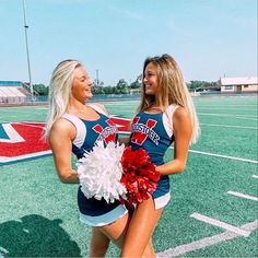 two cheerleaders standing on a football field