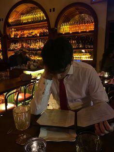 a man sitting at a bar reading a book