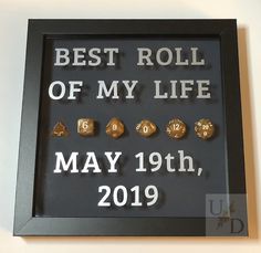 a black frame with gold dices and the words best roll of my life on it