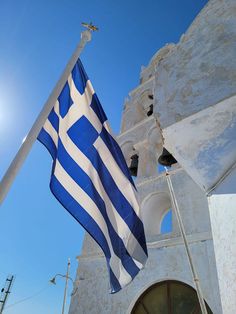 a large blue and white flag flying in front of a building