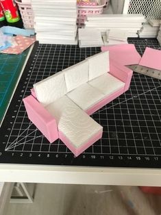 a pink and white couch sitting on top of a table next to stacks of books