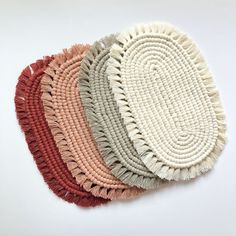 four round rugs with different colors and fringes on them, arranged in a row