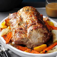 a white bowl filled with meat and veggies next to a glass of orange juice