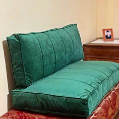 a green couch sitting on top of a wooden floor