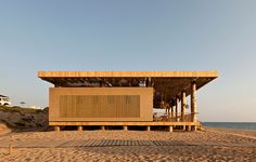 a wooden structure sitting on top of a sandy beach