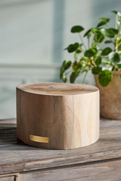 a wooden box sitting on top of a table next to a potted plant