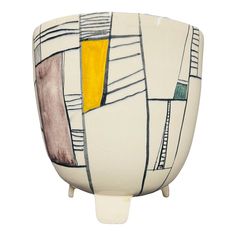 a white vase with yellow and black designs on it