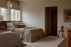 two beds in a bedroom with beige linens