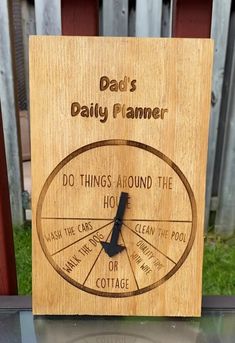 a wooden sign with the words dad's daily planner written on it and an image of a clock