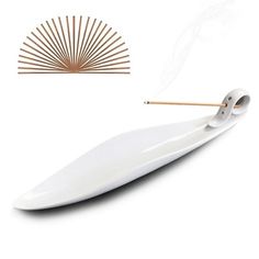 a white incense burner with two sticks sticking out of it